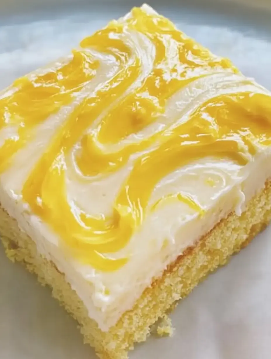 Une portion de gâteau tendre surmonté d'un glaçage crémeux blanc et jaune.