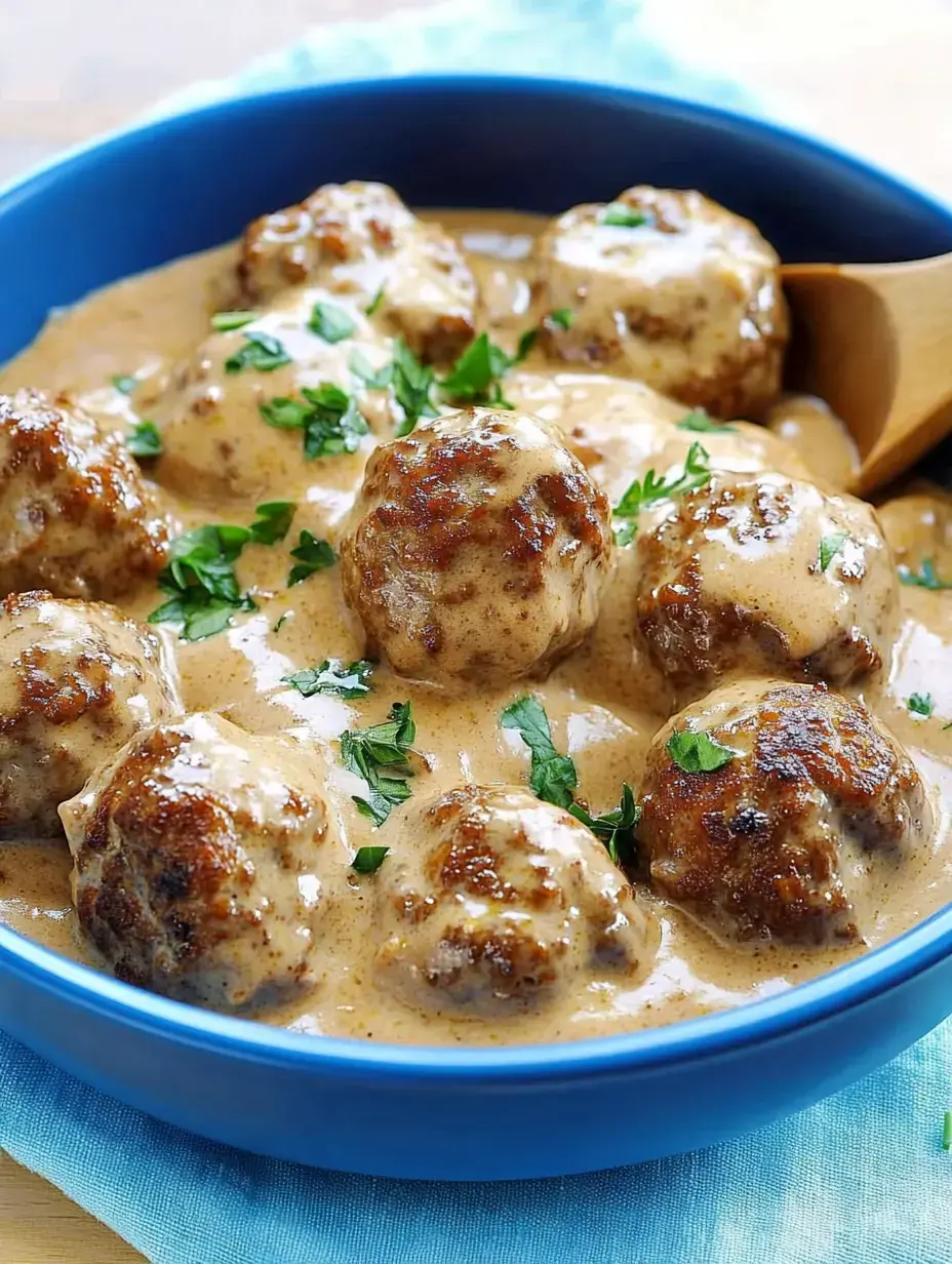 Un bol rempli de savoureuses boulettes dans leur sauce onctueuse, parsemées de persil frais.