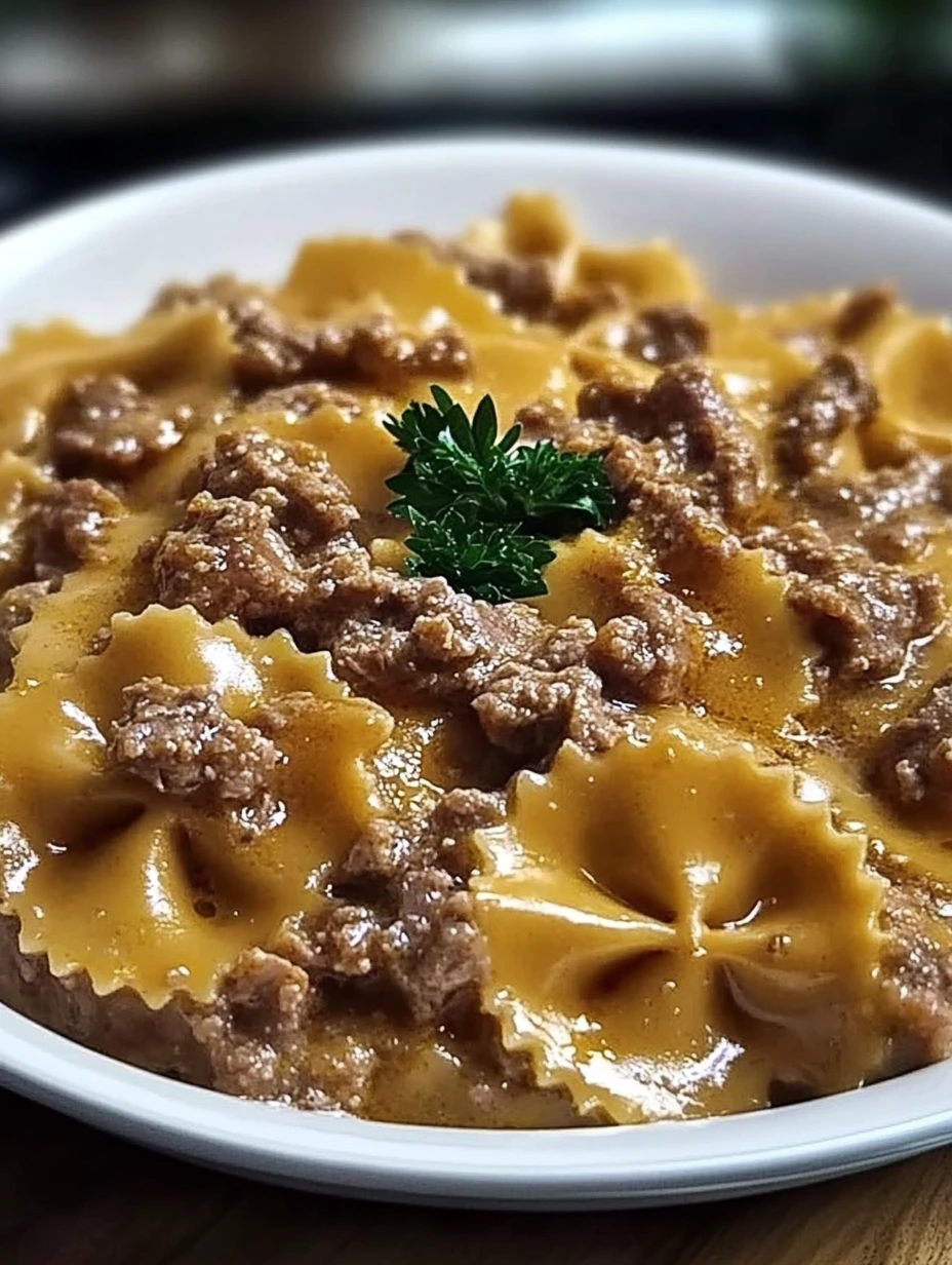 Une assiette de pâtes papillon avec de la viande hachée dessus.