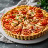 Une tarte aux tomates est servie sur un plateau.