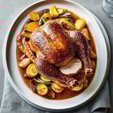 A roasted chicken with a sauce made from apples.
