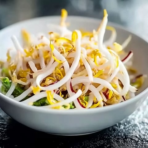 A bowl of vegetables with noodles.